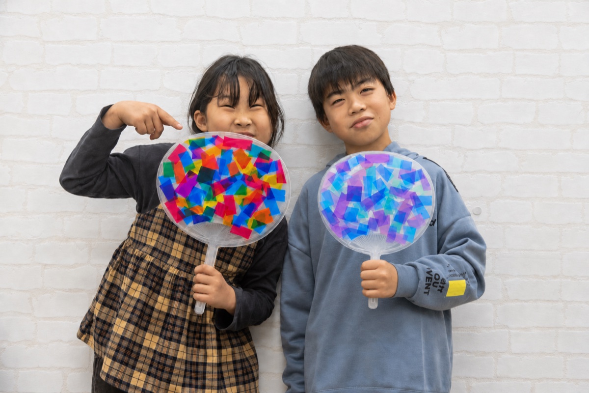 完成したオリジナルうちわを持つ子どもたち